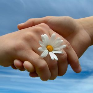 Ladies holding hands with a daisy